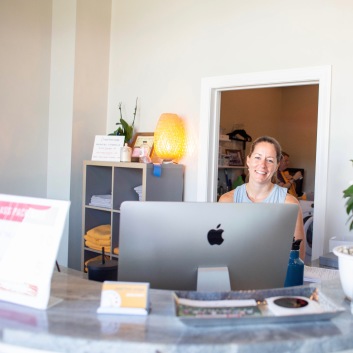 Woman smiling Behind the Reception Desk at Real Hot Yoga