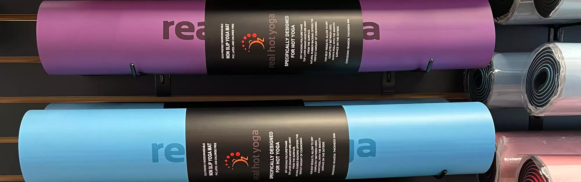 Two rolled up Yoga Mats in Purple and Blue Colors